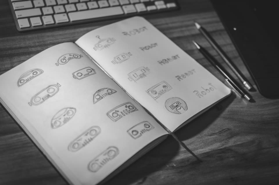 Sketchbook full of hand-drawn logo concepts