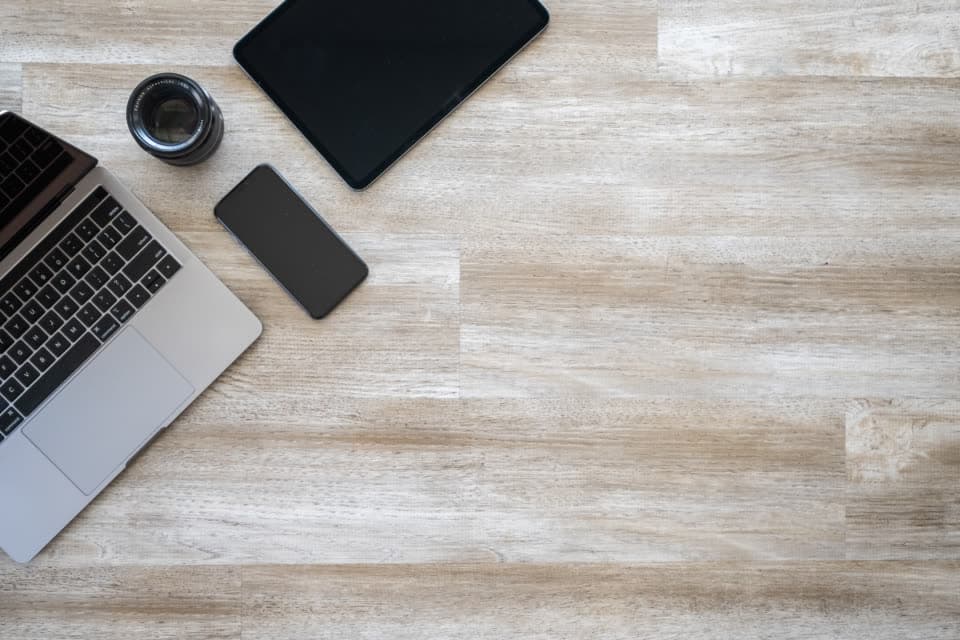 Laptop, tablet, and phone laid out on a desk
