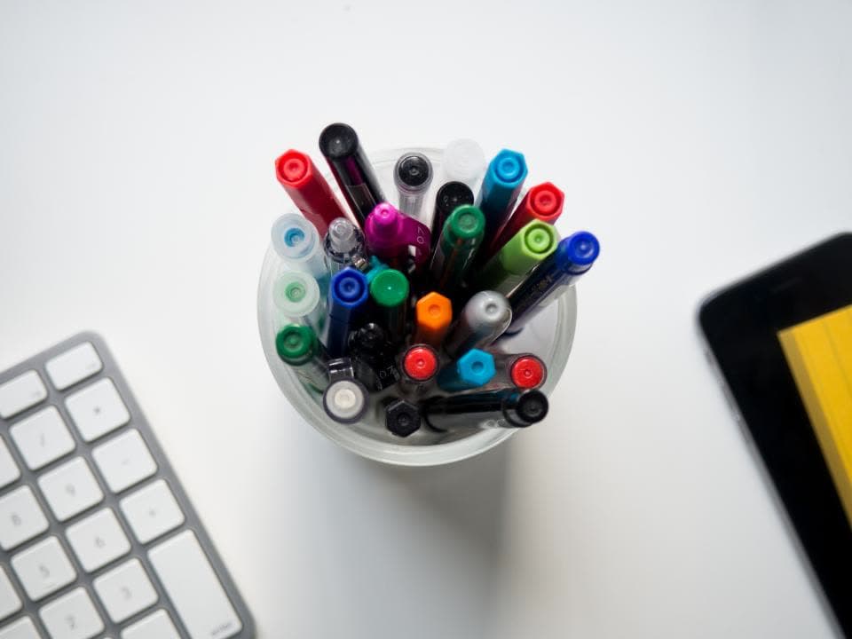 Cup of colorful marker pens on a desk