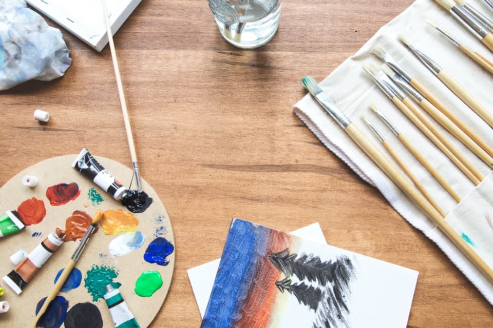 Paint brushes and a color palette on a desk