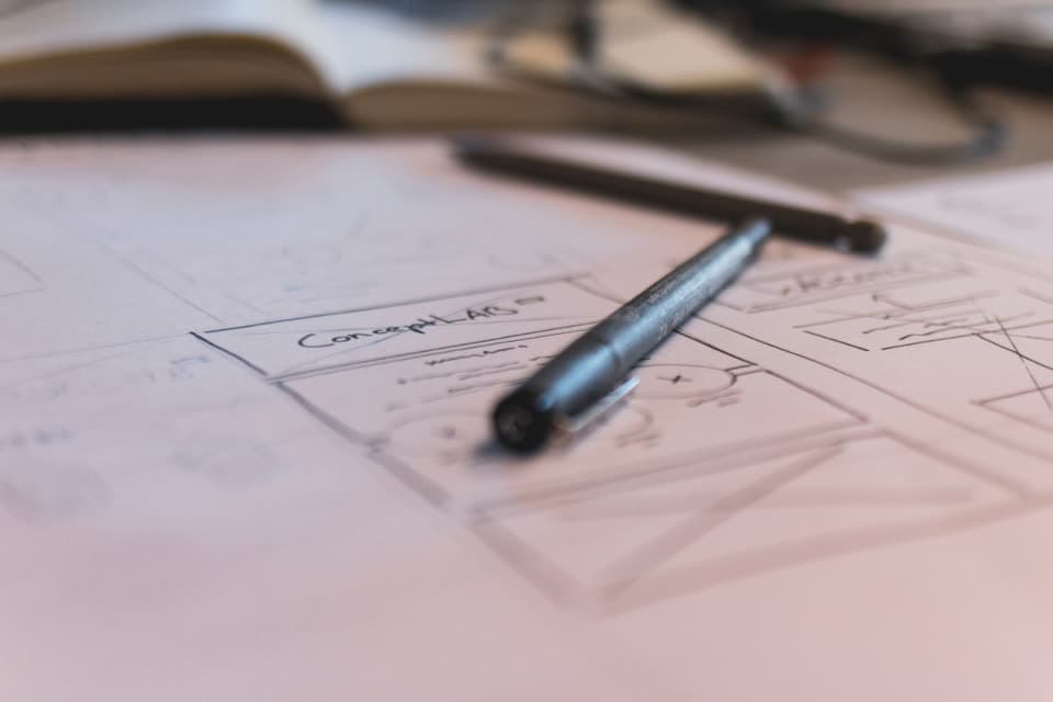 Hand-drawn UI wireframe sketch with a pen