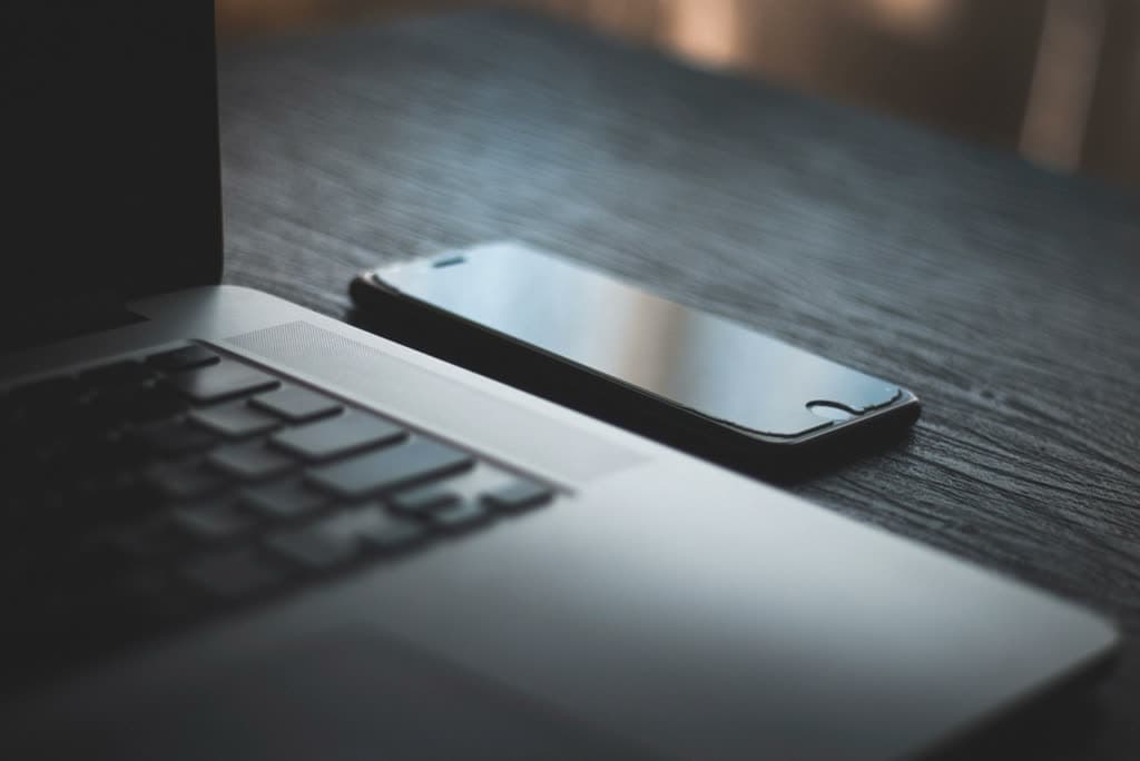 MacBook and iPhone laid out on a desk